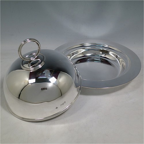 An Antique Victorian Sterling Silver covered muffin dish, having a plain domed lift-off lid with a round reeded handle, sitting on a plain round deep dish with a flat base. Made by William Hutton and Sons of London in 1895. The dimensions of this fine hand-made antique silver muffin dish are height 15 cms (6 inches), diameter of base dish 23 cms (9 inches), and with a total weight of approx. 788g (25 troy ounces).
