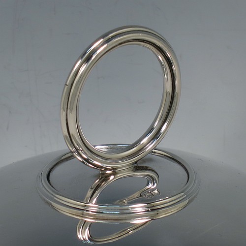 An Antique Victorian Sterling Silver covered muffin dish, having a plain domed lift-off lid with a round reeded handle, sitting on a plain round deep dish with a flat base. Made by William Hutton and Sons of London in 1895. The dimensions of this fine hand-made antique silver muffin dish are height 15 cms (6 inches), diameter of base dish 23 cms (9 inches), and with a total weight of approx. 788g (25 troy ounces).