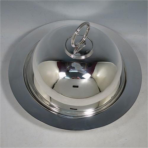 An Antique Victorian Sterling Silver covered muffin dish, having a plain domed lift-off lid with a round reeded handle, sitting on a plain round deep dish with a flat base. Made by William Hutton and Sons of London in 1895. The dimensions of this fine hand-made antique silver muffin dish are height 15 cms (6 inches), diameter of base dish 23 cms (9 inches), and with a total weight of approx. 788g (25 troy ounces).