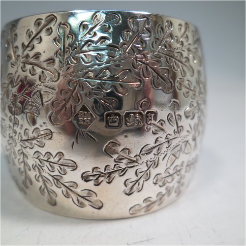 An Antique Victorian Sterling Silver pair of napkin rings, having round bellied bodies with hand-engraved floral decoration surrounding vacant cartouches, all in their original maroon satin and velvet-lined presentation box. Please note that one is engraved with Ivy, and the other with Gingko leaves. Made by Martin and Hall of Sheffield in 1893. The dimensions of these fine hand-made silver napkin rings are diameter 4.5 cms (1.75 inches), height 3.5 cms (1.3 inch), and they weigh a total of approx. 75g (2.4 troy ounces).   