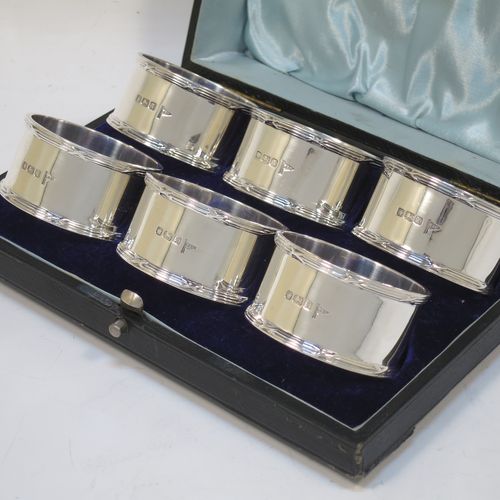 A very handsome Antique Sterling Silver set of six napkin rings, having plain round bodies with straight sides, with applied ribbon and reed borders, all in their original light blue satin and dark-blue velvet-lined presentation box. Made by Walker and Hall of Sheffield in 1915. The dimensions of these fine hand-made antique silver napkin rings are diameter 5 cms (2 inches), height 2.5 cms (1 inch), and they weigh a total of approx. 232g (7.5 troy ounces).