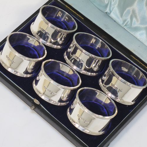A very handsome Antique Sterling Silver set of six napkin rings, having plain round bodies with straight sides, with applied ribbon and reed borders, all in their original light blue satin and dark-blue velvet-lined presentation box. Made by Walker and Hall of Sheffield in 1915. The dimensions of these fine hand-made antique silver napkin rings are diameter 5 cms (2 inches), height 2.5 cms (1 inch), and they weigh a total of approx. 232g (7.5 troy ounces).