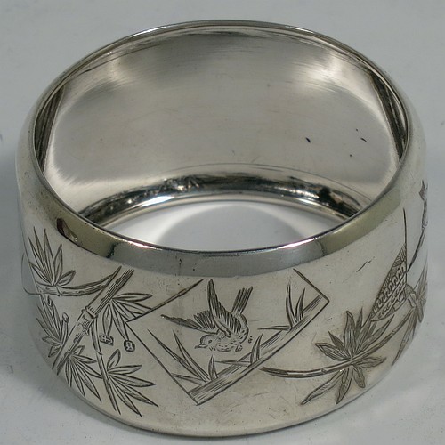 A very pretty Antique Victorian Aesthetic style Sterling Silver pair of napkin rings, having round straight-sided bodies with turned-over borders, and each one hand-engraved differently with Aesthetic decoration of birds, butterflies and bamboo shoots, all in their original cream satin and dark blue velvet-lined presentation box. Made by George Unite of Birmingham in 1881. The dimensions of these fine hand-made antique silver napkin rings are diameter 5 cms (2 inches), height 3 cms (1.25 inches), and they weigh a total of approx. 48g (1.5 troy ounces).