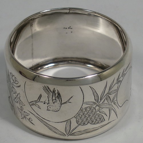 A very pretty Antique Victorian Aesthetic style Sterling Silver pair of napkin rings, having round straight-sided bodies with turned-over borders, and each one hand-engraved differently with Aesthetic decoration of birds, butterflies and bamboo shoots, all in their original cream satin and dark blue velvet-lined presentation box. Made by George Unite of Birmingham in 1881. The dimensions of these fine hand-made antique silver napkin rings are diameter 5 cms (2 inches), height 3 cms (1.25 inches), and they weigh a total of approx. 48g (1.5 troy ounces).