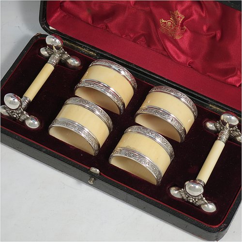 An Antique Victorian Silver-Plated and bone set of four napkin rings and two knife rests, the napkin rings having round straight-sided bodies with applied bands of floral decoration, the knife rests having cast floral supports with button ends, all in their original maroon satin and velvet-lined presentation box. Made by Elkington & Co., in ca. 1880. The dimensions of these fine hand-made antique silver plated and bone napkin rings are diameter 4.5 cms (1.75 inches), height 3 cms (1.25 inch), and the knife rests are 8.5 cms (3.3 inches) long by 4 cms (1.5 inches) high.
