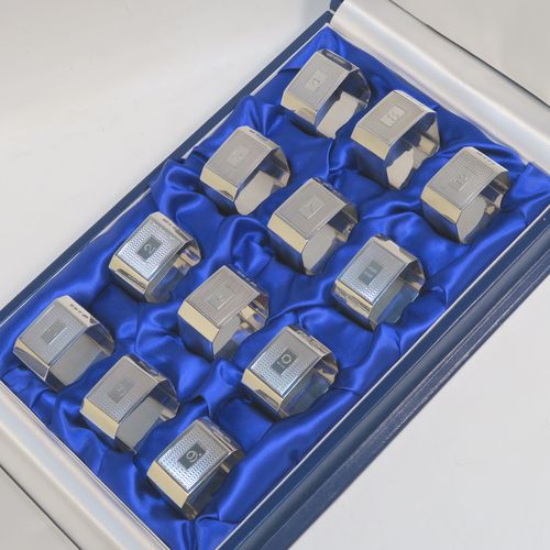A very handsome and rare set of twelve Art Deco Sterling Silver napkin rings, having square bodies with chamfered corners and engine-turned engraving, all in their original cream and dark blue satin presentation box. This beautiful set of twelve silver napkin rings were made by Richard Richardson (poss.) of Birmingham in 1935. The dimensions of these fine hand-made and heavy Art Deco silver napkin rings are length 5 cms (2 inches) square, and they weigh a total of approx. 508g (16.4 troy ounces). Please note that these items are numbered 1 to 12.