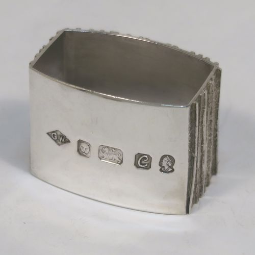 A very unusual Modernistic style Sterling Silver pair of napkin rings, having straight sided rectangular bodies with three sides having a cast bark-like finish, and the fourth side with large spread hallmarks including the Queens Jubilee mark. These beautiful silver napkin rings were made by Graham Watling of London in 1977. The dimensions of these fine hand-made silver napkin rings are length 4.5 cms (1.75 inches), height 3 cms (1.25 inches), and they weigh a total of approx. 93g (3 troy ounces).