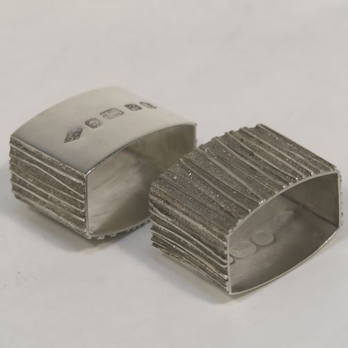 A very unusual Modernistic style Sterling Silver pair of napkin rings, having straight sided rectangular bodies with three sides having a cast bark-like finish, and the fourth side with large spread hallmarks including the Queens Jubilee mark. These beautiful silver napkin rings were made by Graham Watling of London in 1977. The dimensions of these fine hand-made silver napkin rings are length 4.5 cms (1.75 inches), height 3 cms (1.25 inches), and they weigh a total of approx. 93g (3 troy ounces).