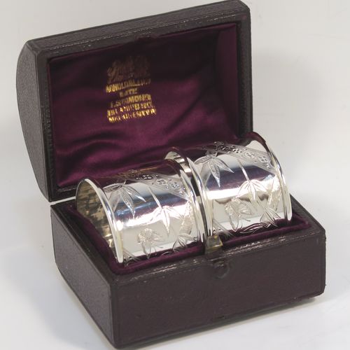 A very pretty Antique Victorian Sterling Silver pair of napkin rings, in an Aesthetic style having round straight-sided bodies with hand-engraved bamboo and butterfly decoration, and all in their original maroon satin and velvet-lined presentation box. These beautiful antique silver Aesthetic style napkin rings were made by Martin Hall and Co., of Sheffield in 1887. The dimensions of these fine hand-made antique silver napkin rings are diameter 4 cms (1.5 inches), height 3 cms (1 inch), and they weigh a total of approx. 34g (1 troy ounce).   