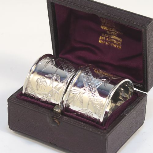 A very pretty Antique Victorian Sterling Silver pair of napkin rings, in an Aesthetic style having round straight-sided bodies with hand-engraved bamboo and butterfly decoration, and all in their original maroon satin and velvet-lined presentation box. These beautiful antique silver Aesthetic style napkin rings were made by Martin Hall and Co., of Sheffield in 1887. The dimensions of these fine hand-made antique silver napkin rings are diameter 4 cms (1.5 inches), height 3 cms (1 inch), and they weigh a total of approx. 34g (1 troy ounce).