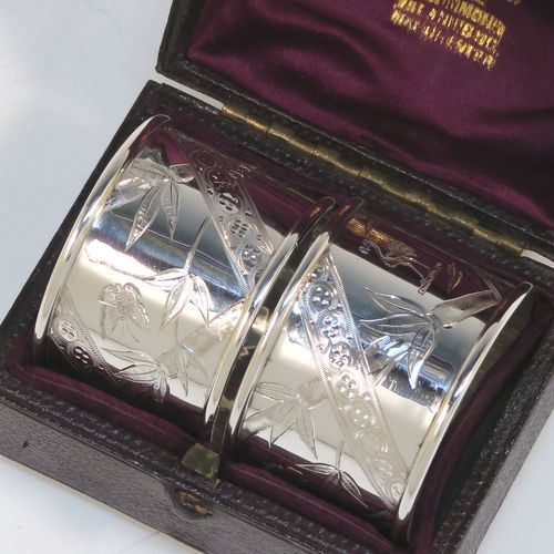 A very pretty Antique Victorian Sterling Silver pair of napkin rings, in an Aesthetic style having round straight-sided bodies with hand-engraved bamboo and butterfly decoration, and all in their original maroon satin and velvet-lined presentation box. These beautiful antique silver Aesthetic style napkin rings were made by Martin Hall and Co., of Sheffield in 1887. The dimensions of these fine hand-made antique silver napkin rings are diameter 4 cms (1.5 inches), height 3 cms (1 inch), and they weigh a total of approx. 34g (1 troy ounce).