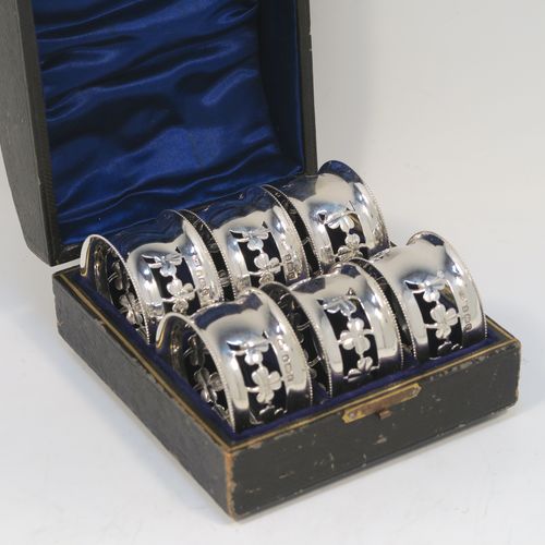 A pretty Antique Edwardian Sterling Silver set of six napkin rings, having round straight-sided bodies, with hand-pierced three-leaf clover Shamrock style decoration, and with bead borders, all in their original dark-blue satin and velvet-lined presentation box. These beautiful silver napkin rings were made by Charles Horner of Birmingham in 1902. The dimensions of these fine hand-made silver napkin rings are diameter 4.5 cms (1.75 inches), height 2.5 cms (1 inch), and they weigh a total of approx. 95g (3.6 troy ounces).   