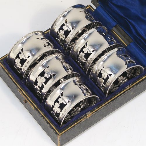A pretty Antique Edwardian Sterling Silver set of six napkin rings, having round straight-sided bodies, with hand-pierced three-leaf clover Shamrock style decoration, and with bead borders, all in their original dark-blue satin and velvet-lined presentation box. These beautiful silver napkin rings were made by Charles Horner of Birmingham in 1902. The dimensions of these fine hand-made silver napkin rings are diameter 4.5 cms (1.75 inches), height 2.5 cms (1 inch), and they weigh a total of approx. 95g (3.6 troy ounces).