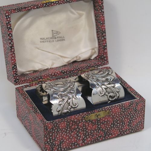 A very pretty Antique Victorian Sterling Silver pair of napkin rings, having round straight-sided bodies with hand-chased floral and scroll decoration surrounding an oval vacant cartouche on one side, all in their original cream satin and dark blue velvet-lined presentation box. These beautiful antique silver napkin rings were made by George Maudsley Jackson of London in 1898. The dimensions of these fine hand-made antique silver napkin rings are diameter 4.5 cms (1.75 inches), height 3 cms (1 inches), and they weigh a total of approx. 56g (1.8 troy ounces).   
