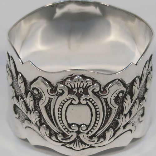 A very pretty Antique Victorian Sterling Silver pair of napkin rings, having round straight-sided bodies with hand-chased floral and scroll decoration surrounding an oval vacant cartouche on one side, all in their original cream satin and dark blue velvet-lined presentation box. These beautiful antique silver napkin rings were made by George Maudsley Jackson of London in 1898. The dimensions of these fine hand-made antique silver napkin rings are diameter 4.5 cms (1.75 inches), height 3 cms (1 inches), and they weigh a total of approx. 56g (1.8 troy ounces).