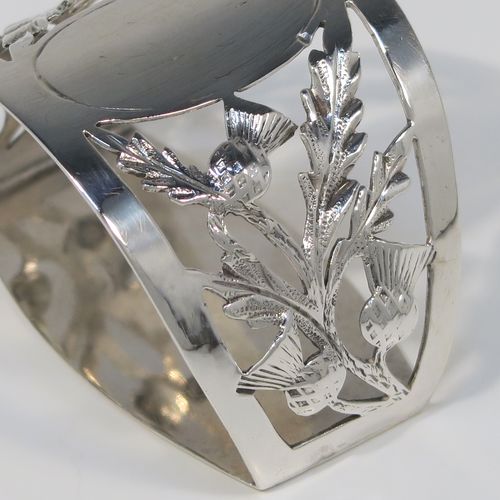 A very pretty Antique Art Nouveau style Sterling Silver pair of napkin rings, having semi-circular bodies with flat sides, with hand-pierced Scottish Thistle floral decoration, surrounding vacant oval cartouches. These beautiful antique silver napkin rings were made by Walker and Hall of Sheffield in 1911. The dimensions of these fine hand-made antique silver napkin rings are length 5 cms (2 inches), height 3.5 cms (1.3 inches), and they weigh a total of approx. 56g (1.8 troy ounces).