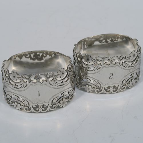 A very pretty and heavy Antique Victorian Sterling Silver pair of napkin rings, having oval straight-sided bodies with hand-pierced and engraved floral and scroll decoration, all in their original cream satin and dark blue velvet-lined presentation box. These beautiful antique silver napkin rings were made by Alexander Clarke of Sheffield in 1901. The dimensions of these fine hand-made antique silver napkin rings are length 6 cms (2.25 inches), height 3.5 cms (1.3 inches), and they weigh a total of approx. 93g (3 troy ounces). Please note that these napkin rings are numbered one and two.