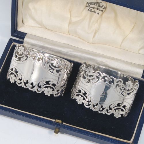 A very pretty and heavy Antique Victorian Sterling Silver pair of napkin rings, having oval straight-sided bodies with hand-pierced and engraved floral and scroll decoration, all in their original cream satin and dark blue velvet-lined presentation box. These beautiful antique silver napkin rings were made by Alexander Clarke of Sheffield in 1901. The dimensions of these fine hand-made antique silver napkin rings are length 6 cms (2.25 inches), height 3.5 cms (1.3 inches), and they weigh a total of approx. 93g (3 troy ounces). Please note that these napkin rings are numbered one and two.