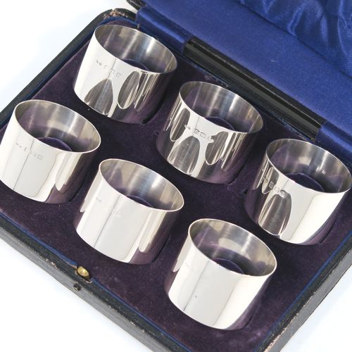 A very handsome Sterling Silver set of six napkin rings, having plain round bodies with straight sides, all in their dark blue satin and velvet-lined presentation box. These elegant silver napkin rings were made by Docker and Burn Ltd., of Birmingham in 1929. The dimensions of these fine hand-made silver napkin rings are diameter 4 cms (1.5 inches), height 3 cms (1.25 inches), and they weigh a total of approx. 187g (6 troy ounces).