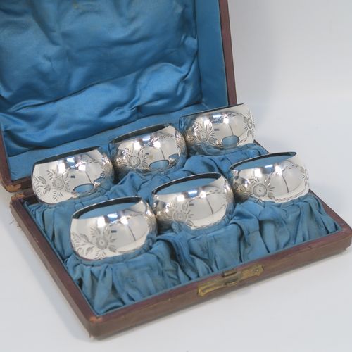 A set of six Antique Sterling Silver napkin rings, having round bellied bodies with hand-engraved floral decoration surrounding vacant cartouches, all in their original light blue satin-lined presentation box. This beautiful set of silver napkin rings were made by Joseph Gloster of Birmingham 1913. The dimensions of these fine hand-made antique silver napkin rings are diameter 5 cms (2 inches), height 2.5 cms (1 inch), and they weigh a total of approx. 107g (3.5 troy ounces).  