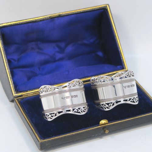 A very pretty Antique Edwardian Sterling Silver pair of napkin rings, having round straight-sided bodies, with hand-pierced scroll borders above two bands of bead work, all in their original dark blue satin and velvet-lined presentation box. These beautiful antique silver napkin rings were made by Roberts and Belk of Sheffield in 1903. The dimensions of these fine hand-made antique silver napkin rings are diameter 4.5 cms (1.75 inches), height 3.5 cms (1.3 inches), and they weigh a total of approx. 52g (1.6 troy ounces).  