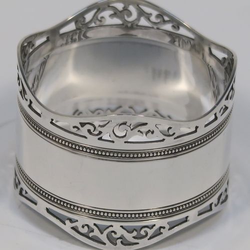 A very pretty Antique Edwardian Sterling Silver pair of napkin rings, having round straight-sided bodies, with hand-pierced scroll borders above two bands of bead work, all in their original dark blue satin and velvet-lined presentation box. These beautiful antique silver napkin rings were made by Roberts and Belk of Sheffield in 1903. The dimensions of these fine hand-made antique silver napkin rings are diameter 4.5 cms (1.75 inches), height 3.5 cms (1.3 inches), and they weigh a total of approx. 52g (1.6 troy ounces).