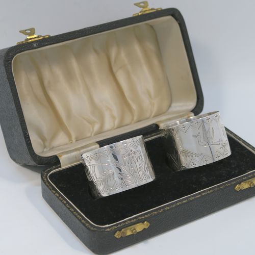 A very pretty pair of Aesthetic style Antique Victorian Sterling Silver napkin rings, having round straight-sided bodies with hand-engraved fern-work decoration and flying crane birds, and all in their original cream satin and black velvet-lined presentation box. These beautiful antique silver Aesthetic style napkin rings were made in London in 1876 and 1877. The dimensions of these fine hand-made antique silver napkin rings are diameter 4 cms (1.5 inches), height 3 cms (1 inch), and they weigh a total of approx. 51g (1.6 troy ounce).   