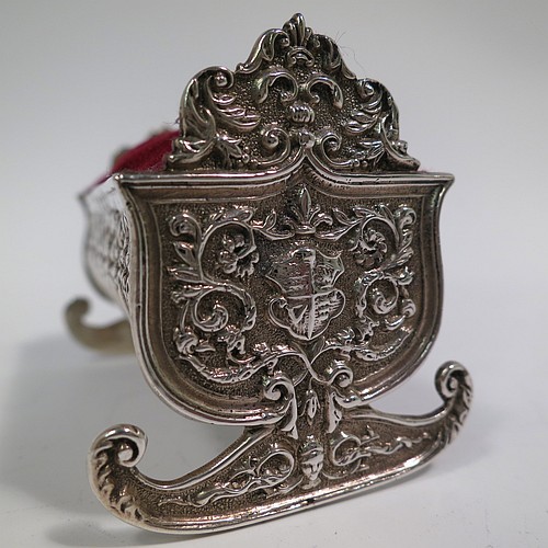 An Antique Victorian Sterling Silver pin cushion, in the form of a babies rocking crib, with hand-chased floral and fluted decoration, together with a maroon velvet covered cushion. Made by Saunders and Shepherd of Birmingham in 1896. The dimensions of this fine hand-made antique silver pin cushion are length 6 cms (2.3 inches), width 3.5 cms (1.3 inches), height 4 cms (1.5 inches), and it weighs approx. 33g (1 troy ounces).   