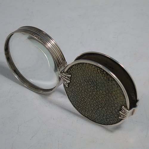 A rare Antique Sterling Silver and Shagreen magnifying glass, having a round body with pull-out and hinged magnifier, with hand-chased reeded borders, and green Shagreen covers. Made by Samuel Jacob of London in 1911. The dimensions of this fine hand-made antique silver and Shagreen magnifying glass and holder are diameter 5 cms (2 inches), length fully unfolded 11 cms (4.3 inches), and depth 1.5 cms (0.5 inch).