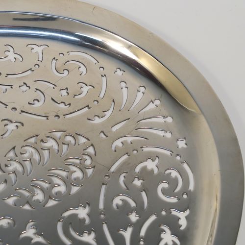 A rare and beautiful Antique Georgian Sterling Silver Mazarine, having an oval body with hand-pierced scroll and geometrical decoration, this draining plate or dish was designed to sit inside a meat or fish platter. This elegant antique silver Mazarine was made by William Hall of London in 1794. The dimensions of this fine hand-made antique silver draining dish or plate are are length 45cms (17.75 inches), width 32 cms (12.5 inches). and it weighs approx.1,054g (34 troy ounces). Please note that his item is crested.