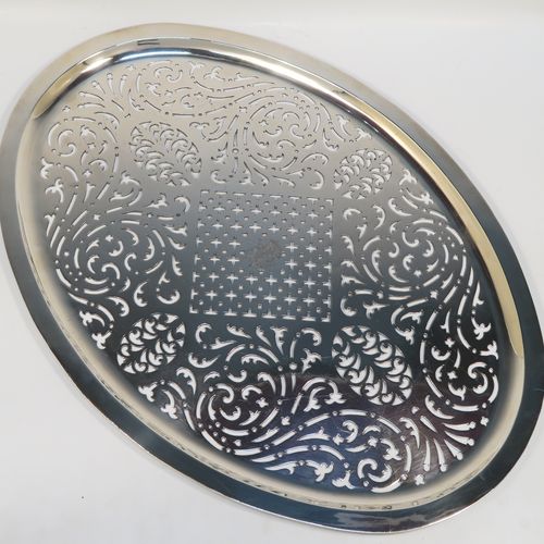 A rare and beautiful Antique Georgian Sterling Silver Mazarine, having an oval body with hand-pierced scroll and geometrical decoration, this draining plate or dish was designed to sit inside a meat or fish platter. This elegant antique silver Mazarine was made by William Hall of London in 1794. The dimensions of this fine hand-made antique silver draining dish or plate are are length 45cms (17.75 inches), width 32 cms (12.5 inches). and it weighs approx.1,054g (34 troy ounces). Please note that his item is crested.