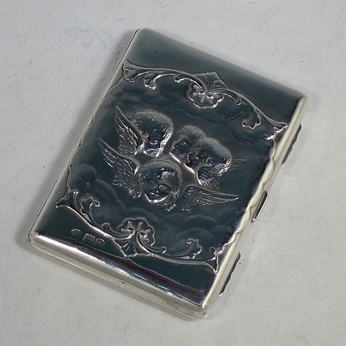 An Antique Victorian Sterling Silver Aide de Memoire and calling card case, having a rectangular body with hand-chased winged cherubs and floral decoration, hinged on one side and with a clasp on the other, and lined with light brown leather pockets. Made by William Comyns of London in 1898. The dimensions of this fine hand-made antique silver Aide de Memoire card case are length 10 cms (4 inches), width 7.5 cms (3 inches), and it weighs approx. 120g (3.9 troy ounces).