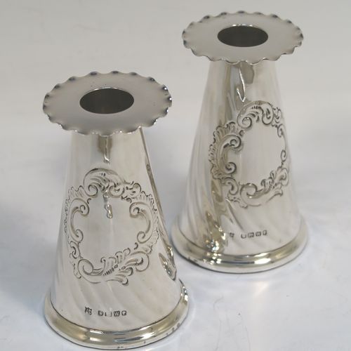 A very pretty Antique Victorian Sterling Silver desk set consisting of an inkstand and a pair of candle holders, in a round style with hand-chased swirl fluting and wavy-edge borders, the inkstand with a hinged lid and glass liner, the candlesticks with removable nozzles. This beautiful silver desk set was made by the Dixon Brothers of Sheffield in 1889. The dimensions of this fine antique silver desk set are height of candlesticks 14 cms (5.5 inches), and diameter of inkstand at base 11.5 cms (4.5 inches).