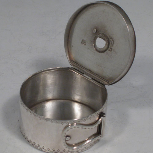 Antique Georgian sterling silver bougie-box, having a cylindrical body with bright-cut engraved bands of decoration, a flat invisibly hinged lid, an attached sickle moon-shaped wax trimmer, and a hinged buckle style loop handle. Made by Thomas Phipps and Edward Robinson II of London in 1785. Please note that the hallmark also includes a rare incuse duty mark (George III looking left), which was only in use for 18 months (between 1st December 1784 and 29th May, 1786). The dimensions of this fine hand-made silver bougie-box are diameter 5 cms (2 inches), height 2.5 cms (1 inch), and it weighs approx. 53g (1.7 troy ounces). 