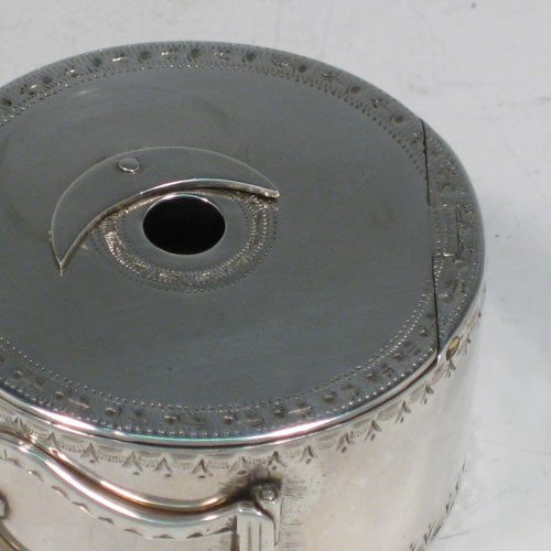 Antique Georgian sterling silver bougie-box, having a cylindrical body with bright-cut engraved bands of decoration, a flat invisibly hinged lid, an attached sickle moon-shaped wax trimmer, and a hinged buckle style loop handle. Made by Thomas Phipps and Edward Robinson II of London in 1785. Please note that the hallmark also includes a rare incuse duty mark (George III looking left), which was only in use for 18 months (between 1st December 1784 and 29th May, 1786). The dimensions of this fine hand-made silver bougie-box are diameter 5 cms (2 inches), height 2.5 cms (1 inch), and it weighs approx. 53g (1.7 troy ounces). 