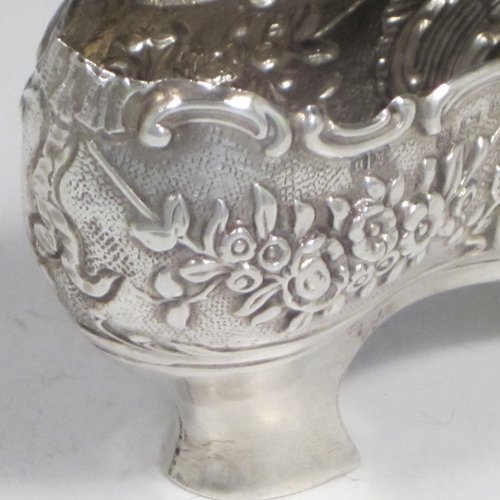 Antique Edwardian sterling silver shoe, having a hand-chased body with floral decoration, with a plain heal, and hand-pierced front laces with a bow. Made by Henry Miller of Birmingham in 1906. The dimensions of this fine hand-made silver shoe are height 5 cms (2 inches), length 11.5 cms (4.5 inches), width 3 cms (1.25 inches), and it weighs approx. 33g (1 troy ounce).