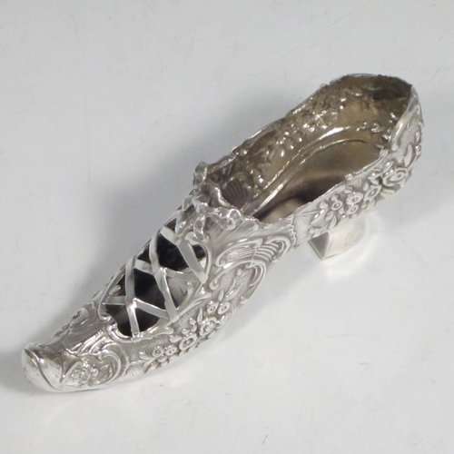 Antique Edwardian sterling silver shoe, having a hand-chased body with floral decoration, with a plain heal, and hand-pierced front laces with a bow. Made by Henry Miller of Birmingham in 1906. The dimensions of this fine hand-made silver shoe are height 5 cms (2 inches), length 11.5 cms (4.5 inches), width 3 cms (1.25 inches), and it weighs approx. 33g (1 troy ounce).