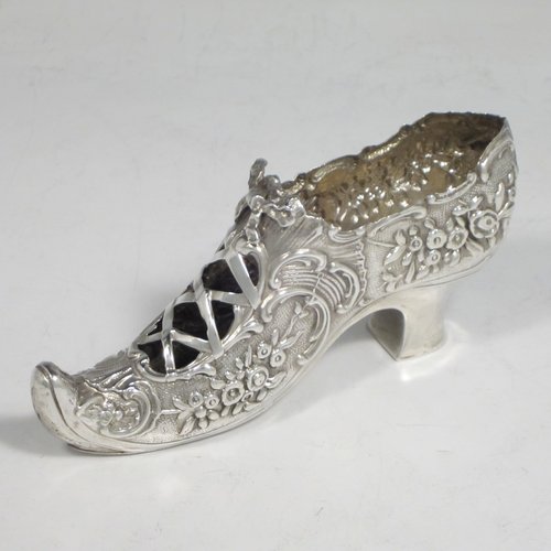 Antique Edwardian sterling silver shoe, having a hand-chased body with floral decoration, with a plain heal, and hand-pierced front laces with a bow. Made by Henry Miller of Birmingham in 1906. The dimensions of this fine hand-made silver shoe are height 5 cms (2 inches), length 11.5 cms (4.5 inches), width 3 cms (1.25 inches), and it weighs approx. 33g (1 troy ounce).