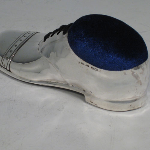 Antique Edwardian sterling silver pin cushion, in the shape of a shoe, having a plain body with laces and an applied decorative band. The dimensions of this fine hand-made silver pin cushion are length 12 cms (4.75 inches), and width 5 cms (2 inches).