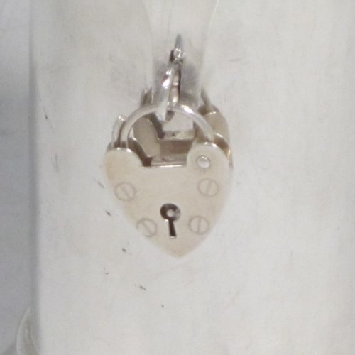 Antique Edwardian sterling silver money box, having a plain round straight-sided body, with hinged money-slot lid, and a hinged clasp with a heart-shaped lock. Made in Birmingham in 1902. The dimensions of this fine hand-made silver money box are height 10 cms (4 inches), diameter at base 6 cms (2.25 inches), and it weighs approx. 95g (3 troy ounces).