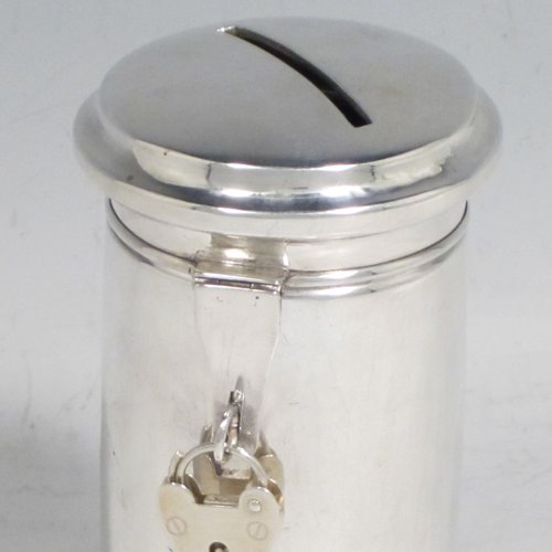 Antique Edwardian sterling silver money box, having a plain round straight-sided body, with hinged money-slot lid, and a hinged clasp with a heart-shaped lock. Made in Birmingham in 1902. The dimensions of this fine hand-made silver money box are height 10 cms (4 inches), diameter at base 6 cms (2.25 inches), and it weighs approx. 95g (3 troy ounces).