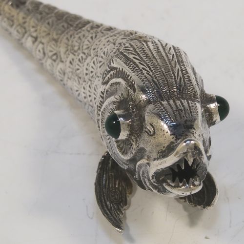 A very pretty Antique Edwardian Silver Articulated fish, having hand-chased scales and fins, and with two green glass eyes. This beautiful articulated silver fish model was made in Cordoba, Spain in ca. 1940. On one of the lower fins you can see the hallmark of a Pentagram that is a Spanish quality mark indicating a minimum of 915 Silver purity (Sterling Standard is 925), and in a separate mark the letters CO representing Cordoba. The dimensions of this fine hand-made antique Articulated Silver fish are length 15 cms (6 inches), height 4 cms (1.5 inches), and it weighs approx. 72g (2.3 troy ounces).