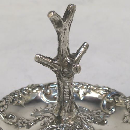 A very pretty Antique Victorian Sterling Silver ring tree, having a central naturalistic tree for rings sitting on a round base with two side-handles, with hand-chased floral and scroll decoration. This beautiful silver ring tree and base was made by Henry Matthews of Birmingham in 1900. The dimensions of this fine hand-made antique silver tree ring are height 7.5 cms (3 inches), diameter 8 cms (3 inches), and it weighs approx. 36g (1.2 troy ounce).   
