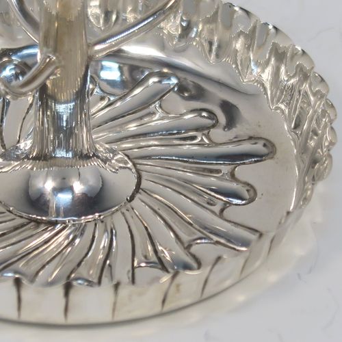 A very pretty Antique Victorian Sterling Silver ring tree, having a central naturalistic tree for rings sitting on a round base with hand-chased swirl-fluted scroll decoration. This beautiful silver ring tree and base was made by Edward Hutton of London in 1893. The dimensions of this fine hand-made antique silver tree ring are height 7 cms (2.75 inches), diameter 8 cms (3.25 inches), and it weighs approx. 44g (1.4 troy ounce).   