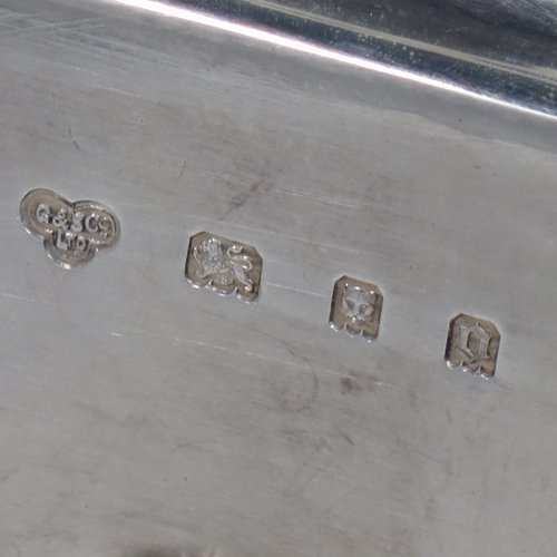 A Sterling Silver oil and vinegar set, having an octagonal boat-shaped body with applied reed-edged borders, a two-bottle frame with loop handle, a pair of hand-cut round crystal bottles with stoppers, and all sitting on four cast scroll feet. Made by Goldsmiths & Silversmiths of London in 1929. The dimensions of this fine hand-made silver oil and vinegar set are length 23 cms (9 inches), height 20 cms (8 inches), width 10 cms (4 inches), and the base weighs approx. 495g (16 troy ounces).