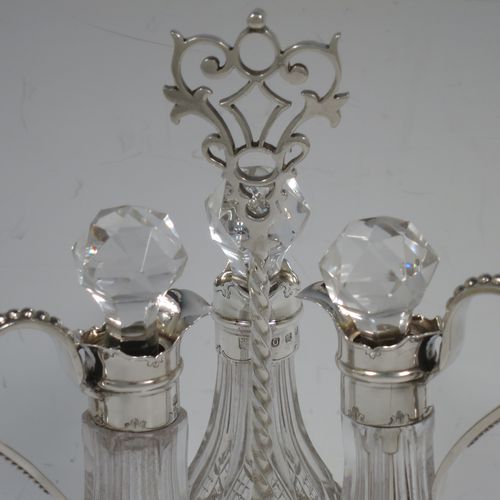 A very pretty Antique Victorian Sterling Silver oil and vinegar set, having three hand-cut crystal bottles with silver mounts, stoppers, and bead-edged scroll handles. All sitting in a hand-pierced frame with matching bead-work, a twisted central and hand-pierced handle, and all sitting on three cast claw and ball feet. Made by Martin Hall and Co., of Sheffield in 1857. The dimensions of this fine hand-made antique silver and crystal oil and vinegar set are height 19 cms (7.5 inches), width 11 cms (4.3 inches), and the frame  weighs approx. 170g (5.5 troy ounces).    