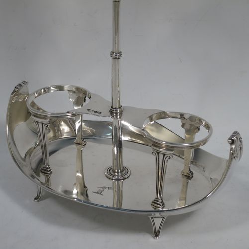 A very handosme Antique Sterling Silver oil and vinegar set in a neoclassical style, having an oval boat-shaped body with applied reed-edged borders, a two-bottle frame with hand-pierced handle, a pair of hand-cut round crystal bottles with panelled bodies and original hinged lid mounts with scroll handles, and all sitting on four flange feet. Made by Goldsmiths & Silversmiths of Sheffield in 1919. The dimensions of this fine hand-made antique silver oil and vinegar set are length 20 cms (8 inches), height 25.5 cms (10 inches), width 14 cms (5.5 inches), and it weighs approx. 250g (8 troy ounces).    