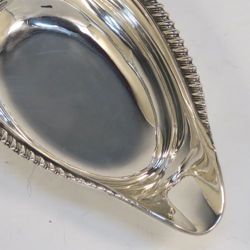 A handsome Antique Georgian Sterling Silver pap boat, in a Regency style having an applied cast gadroon, oak-leaf, and shell upper border, attached to a very plain oval body with a flat base. This elegant antique silver pap boat was made by the Barnard Brothers of London in 1835. The dimensions of this fine hand-made antique silver pap boat are length 13.5 cms (5.25 inches), width 7.5 cms (3 inches), and it weighs approx. 78g (2.5 troy ounces).