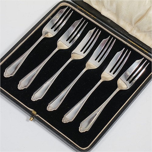 A Sterling Silver set of six pastry forks, having a single-struck reeded Louis pattern handle, and three tined forks, all in their original cream satin and black velvet-lined presentation box. Made by the Cooper Brothers of Sheffield in 1926. The dimensions of these fine hand-made silver pastry forks are length 13 cms (5.25 inches), and they weigh a total of 92g (3 troy ounces).