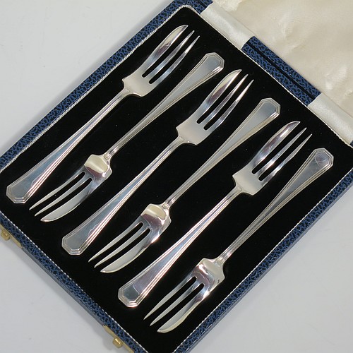A Sterling Silver Art Deco style set of six pastry forks, having a double-struck plain reeded Athenian pattern handle, and three tined forks, all in their original cream satin and black velvet-lined presentation box. Made by Mappin and Webb of Sheffield in 1963. The dimensions of these fine hand-made silver pastry forks are length 13 cms (5.25 inches), and they weigh a total of 103g (3.3 troy ounces).